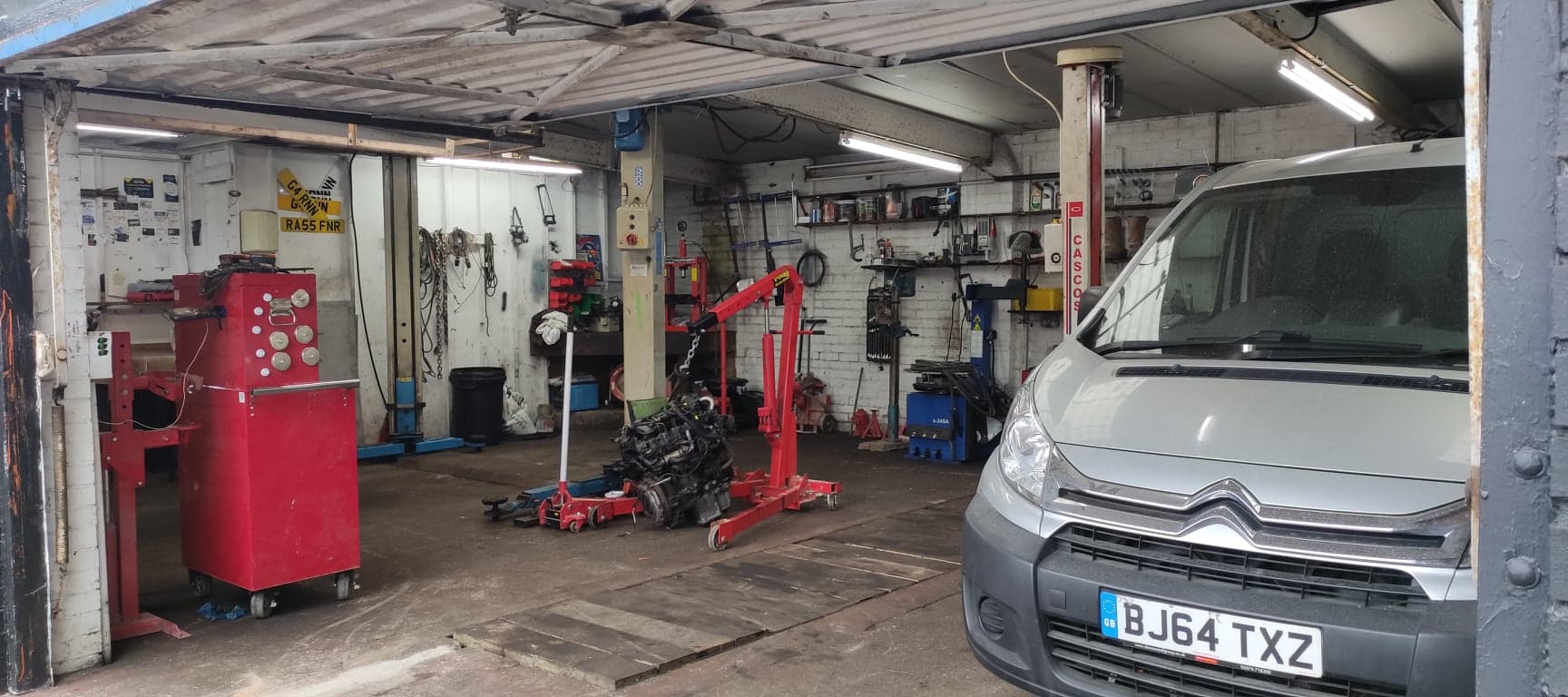 Inside Old Otley Workshop, with a van beside the vehicle lift and workshop equipment